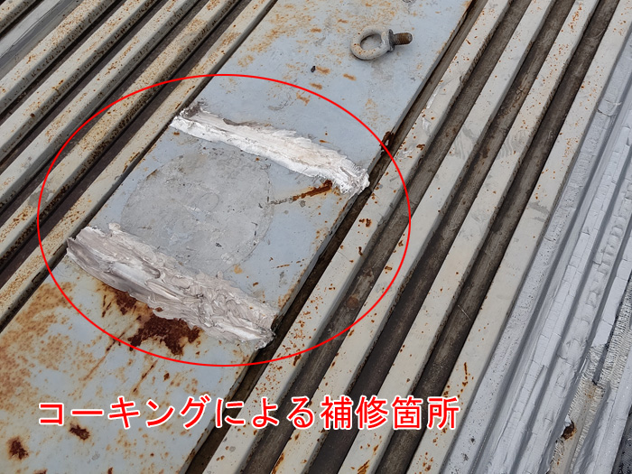 屋根をコーキングで補修している