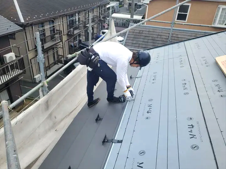 屋根葺き替え工事を行う職人