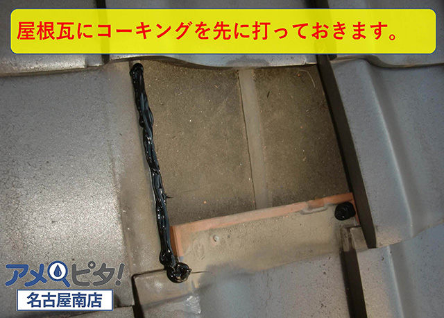 新しい屋根瓦を差し替える前に周辺の瓦に接着用のコーキングボンドを塗っておきます