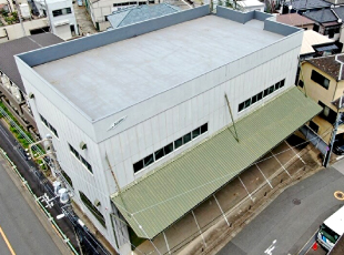 雨漏りしている大きな倉庫を上空から撮影