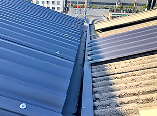 泥やゴミを撤去し、新しい谷板金を設置