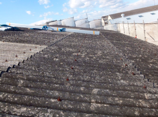 全体にひび割れや劣化が見られる古い大波スレート屋根