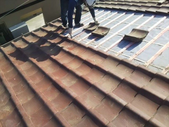 一枚一枚の位置を微調整して全体の噛み合わせを確認しつつ瓦屋根を復旧