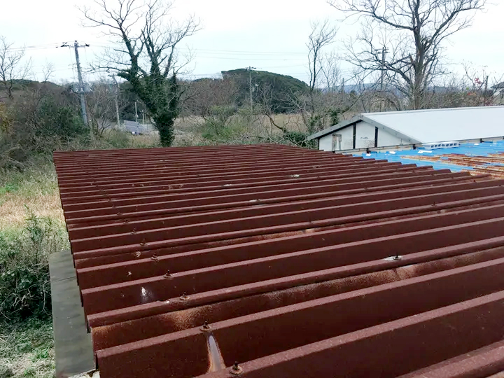 錆による腐食で全体が赤茶色くなった折板屋根