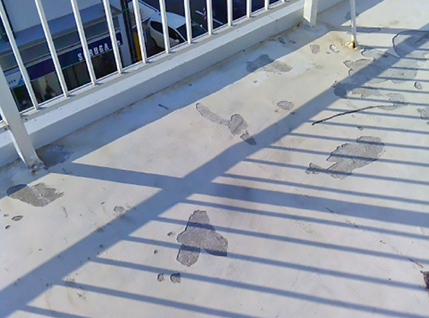 鉄骨ビルの屋上の床が剥がれて下地が剥き出しに